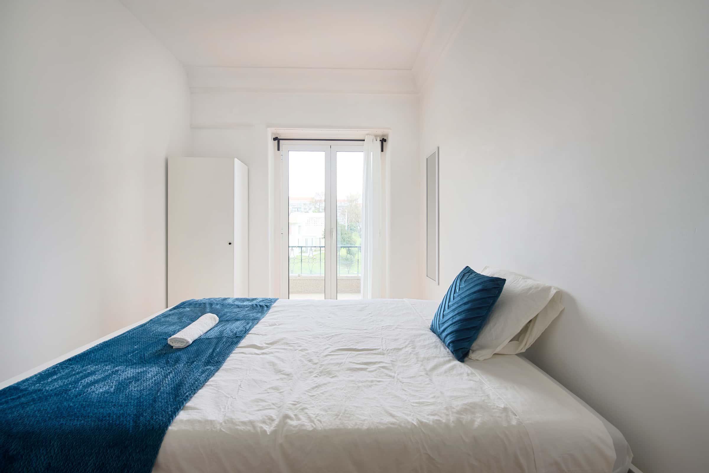 Bedroom with balcony in a 9-Bedroom Apartment in Rua Jorge Ferreira de Vasconcelos, Lisbon - Room 1